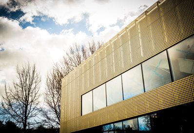 Exterior of the Advanced Engineering Building at the University of Brighton showing its unique gold perforated facade and flat windows