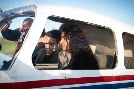 Three students inside a light aircraft